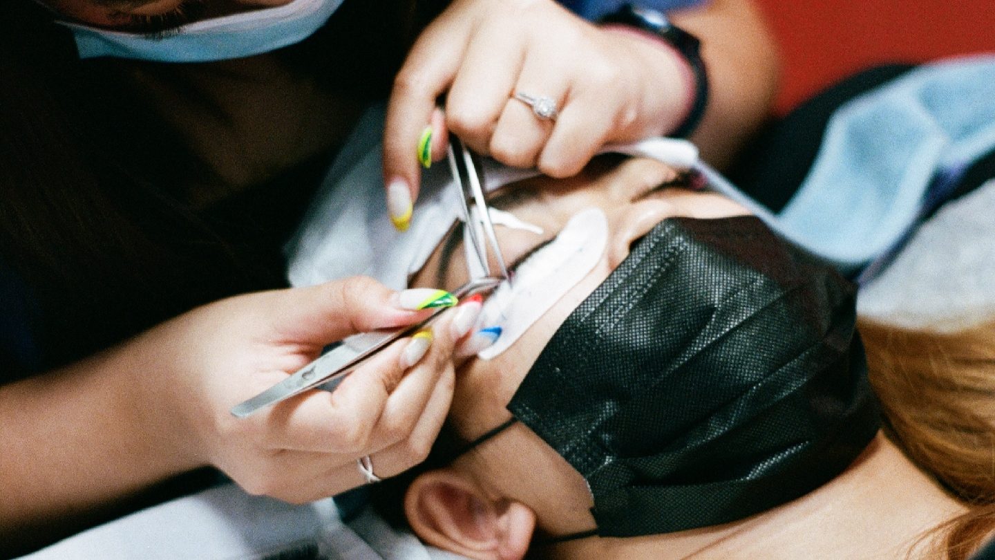 A lash artist working on a client's lashes